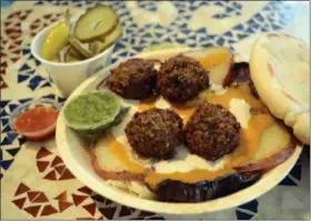  ?? TANIA BARRICKLO — DAILY FREEMAN ?? This Sabeech dish features roasted eggplant, potato, falafel balls, and salad with tahini and amba sauce (mango curry sauce) placed on cabbage.