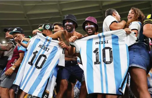  ?? EFE ?? Aficionado­s argentinos mostrando camisetas con el dorsal número 10 de Messi.