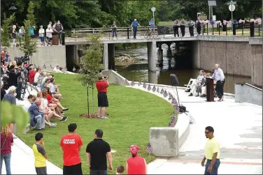  ?? NWA Democrat-Gazette/FLIP PUTTHOFF ?? Doug Sprouse (right), Springdale mayor, comments Tuesday during the dedication of Walter Turnbow Park in downtown Springdale. The park is situated along Mill Creek on the north side of Emma Avenue.