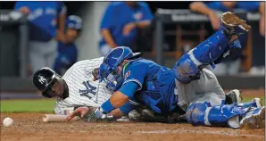  ?? AP PHOTO/KATHY WILLENS ?? The ball rolls away as Toronto Blue Jays catcher Luke Maile, right, collides with New York Yankees' Didi Gregorius, left, who scored on Ronald Torreyes' ground ball to the pitcher on a fielder's choice during the eighth inning of a baseball game in New...