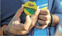  ??  ?? Orozco, who is challengin­g Rep. Sheila Jackson Lee, puts on a button touting his support for Medicare for all Americans.