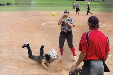  ?? Staff photo by Joshua Boucher ?? The Texas Slams' Marley Mahoney slides into home as the Hawks' Skylar Wooten attempts to tag her out Saturday at Hobo Jungle Park in Texarkana.