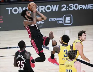  ?? POOL Getty Images ?? Derrick Jones Jr. shoots against Indiana’s Aaron Holiday in the first half Friday. The Heat forward left the game on a stretcher after a hard collision in the third period and was diagnosed with a neck strain.