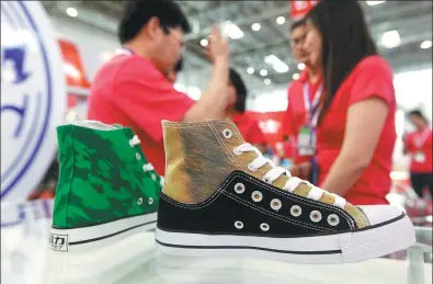  ?? PROVIDED TO CHINA DAILY ?? Patented Warrior shoes made of reflective fabric are displayed at a sportswear expo in Beijing. With more than 90 years of history, Warrior has transforme­d itself by enhancing designs and selling the shoes through e-commerce platforms.