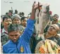  ?? AFP ?? A villager shows fishes as buyers gather around him during the community fishing in Guwahati. —