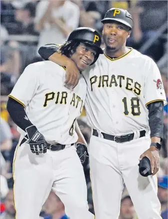  ?? Gene J. Puskar Associated Press ?? GIFT NGOEPE grew up in South Africa, toiled eight years in Pirates’ system, was called up in April ... and singled in his first big league at-bat, an emotional moment for him and coach Kimera Bartee (18).