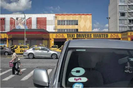  ?? Dave Sanders / New York Times ?? A for-hire vehicle driver waits near a taxi garage in Brooklyn, N.Y. Mayor Bill de Blasio wants to extend a cap on Uber vehicles, prompting Uber to sue the city to overturn the law.