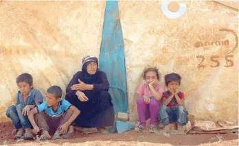  ?? — AFP ?? Displaced Syrians rest by a tent at a camp in Kafr Lusin near the border with Turkey in the northern part of Syria’s rebel-held Idlib province on Saturday.