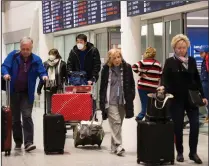  ?? CP PHOTO NATHAN DENETTE ?? People wear masks as a precaution due to the coronaviru­s outbreak as they arrive at the Internatio­nal terminal at Toronto Pearson Internatio­nal Airport in Toronto on Saturday, January 25, 2020.