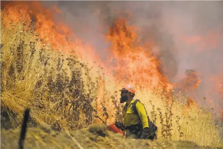  ?? Randall Benton / Sacramento Bee ?? Hot Shot crews from Mendocino County use backfires to fight the County Fire near Lake Berryessa, now nearly contained.
