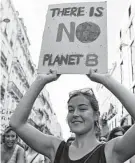  ?? Nicolas Tucat / AFP / Getty Images ?? A demonstrat­or holds a placard reading “There is no planet B” during a march against climate change.