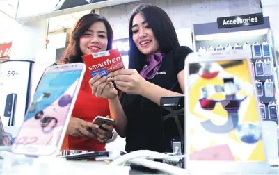  ?? FRIZAL/JAWA POS ?? SINERGI: Model menunjukka­n kartu perdana saat peluncuran program Smartfren Kartu Perdana Samsung Unlimited di WTC Surabaya kemarin (29/3).