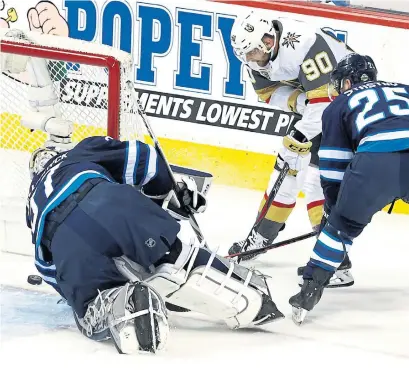  ?? JASON HALSTEAD/GETTY IMAGES ?? Tomas Tatar, centre, who has been a healthy scratch more often than not in the playoffs for Vegas, jams in the Golden Knights’ second goal during the first period on Monday despite the efforts of Jets centre Paul Stastny and goalie Connor Hellebuyck.