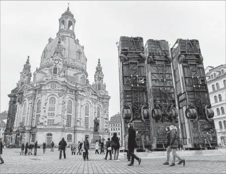  ?? Filip Singer European Pressphoto Agency ?? SYRIAN-GERMAN artist Manaf Halbouni created “Monument” by standing upright three massive buses in Dresden’s central town square. He had seen a similar scene in Aleppo, where the buses served as a makeshift barricade to protect civilians from sniper fire.