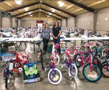  ?? SUBMITTED ?? Allison Phelps of the United Way, left, and Tiffany Henson from the Independen­ce County Entergy Plant help fill requests for bicycles at the Independen­ce County Fairground­s during Angel Tree gift distributi­on.