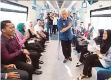  ?? PIC BY MOHAMAD SHAHRIL BADRI SAALI ?? Higher Education Minister Datuk Seri Idris Jusoh (centre) sharing a ride with students on an MRT train in Kuala Lumpur yesterday.