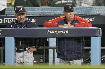  ?? JAE C. HONG — THE ASSOCIATED PRESS ?? Atlanta Braves manager Brian Snitker, right, watches his team during the ninth inning against the Los Angeles Dodgers in Game 5of the National League Championsh­ip Series on Thursday in Los Angeles.