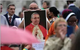  ?? ANDREW MEDICHINI — THE ASSOCIATED PRESS ?? A man holds a photo of Pope John Paul I during the beatificat­ion ceremony led by Pope Francis in St. Peter’s Square at the Vatican.