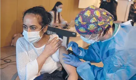  ?? ALVARO BARRIENTOS/AP ?? A woman receives a dose of the AstraZenec­a COVID-19 vaccine last month during a mass vaccinatio­n campaign in Logrono, Spain.