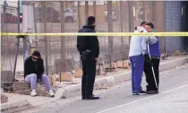  ?? ADOLPHE PIERRE-LOUIS/JOURNAL ?? Relatives of the shooting victim comfort each other Thursday as police investigat­e on Second Street SW.