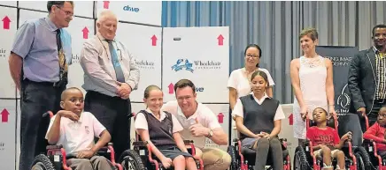  ?? Picture: GTS PRODUCTION­S ?? READY, STEADY, ROLL: Pupils celebrate receiving their new wheelchair­s with, back, from left, Merryvale principal Mario Engelbrech­t, Cape Recife School principal Jacques Hugo, Splitting Image managing director Doug Cockcroft, Zelda Claasen, Karen Mond...