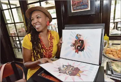  ?? HYOSUB SHIN / HSHIN@AJC.COM ?? Comic book artist Afua Richardson, the illustrato­r on John Lewis’ new graphic novel “Run,” shows off her puckish version of the Powerpuff Girls. (She turns the superheroe­s into girls of color and calls them Cocoa Puff Girls.)