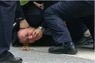  ?? ?? FILE - Chinese policemen pin down a protester and covered his mouth during a protest on a street in Shanghai, China on Nov. 27, 2022. What started as an unplanned vigil last weekend in Shanghai by fewer than a dozen people grew hours later into a rowdy crowd of hundreds. The protesters expressed anger over China’s harsh COVID-19 policies that they believed played a role in the deadly fire on Nov. 24 in a city in the far west. (AP Photo, File)