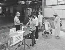  ?? SHA XIAOFENG / FOR CHINA DAILY ?? People scan health codes before entering a grocery market in Sanya, Hainan province, on Wednesday.