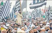  ?? REUTERS ?? ■
A supporter of the party Jamiat Ulema-i-Islam-Fazal (JUI-F) holds a flag while others listen to a speech during a rally in Islamabad.