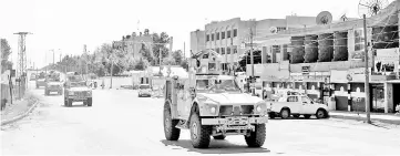  ??  ?? Vehicles from the US-led coalition battling the Islamic State group patrol the town of Rmelane in Syria’s Hasakeh province. — AFP photo