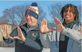  ?? KIRSTEN STICKNEY/SUN-TIMES ?? Miami coach Mario Cristobal (left) and Nate Marshall hold up “The U” sign on Fenwick’s soccer field Tuesday in River Forest.