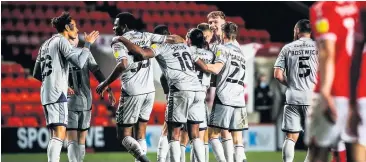  ??  ?? Burton players celebrate Danny Rowe’s winning goal.