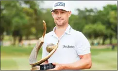  ?? ?? Taylor Moore holds the trophy after winning the Valspar Championsh­ip golf tournament at Innisbrook in Palm Harbor, Fla. (AP)