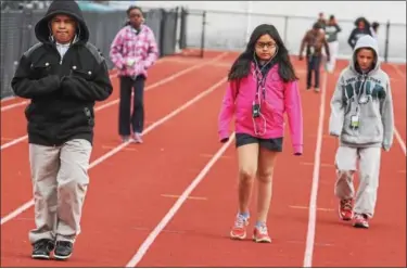  ?? KEVIN HOFFMAN — THE MERCURY ?? Above, Pottstown Middle School students walk around the high school track to stay fit and healthy. At right, Amiya Mayes and Emily Careme play during recess wearing their favorite pajamas during Lincoln Elementary School pajama day. parent engagement...