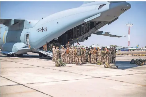  ?? FOTO: MARC TESSENSOHN/BUNDESWEHR/DPA ?? Deutsche Fallschirm­jäger steigen auf dem Flughafen von Taschkent in Usbekistan in ein Transportf­lugzeug der Bundeswehr.