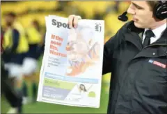  ?? AFP ?? A television reporter holds up a newspaper with an image of British and Irish Lions coach Warren Gatland depicted as a clown before their match against the Wellington Hurricanes on Tuesday.