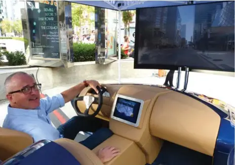  ?? STEPHANIE WALLCRAFT FOR THE TORONTO STAR ?? Derek Colfer, head of technology for Visa Canada, demonstrat­es the Visa connected car concept that was on display at TIFF last fall.