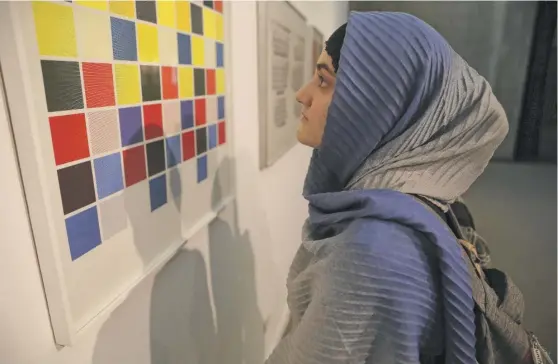  ?? VAHID SALEMI/AP ?? A visitor looks at artworks by American artist Sol Lewitt at the Tehran Museum of Contempora­ry Art in Tehran, Iran, Aug. 2.