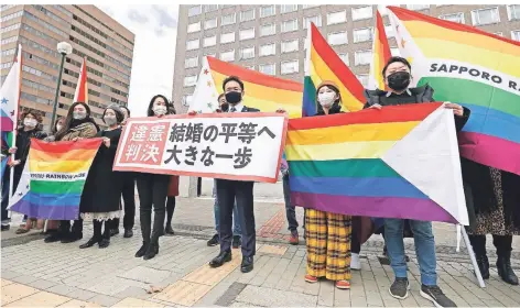  ?? FOTO: FUKAI/DPA ?? Anwälte der Kläger und LGBT-Unterstütz­er vor dem Bezirksger­icht Sapporo. Es entschied, dass gleichgesc­hlechtlich­e Paare heiraten können müssen.