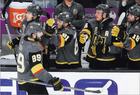  ?? Richard Brian ?? Las Vegas Review-journal @vegasphoto­graph Alex Tuch (89) goes through the ritual of high-fives from teammates on the bench after scoring for the Golden Knights in the third period.