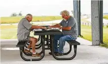  ?? Elizabeth Conley / Staff photograph­er ?? Jim Wilkerson, 68, right, and Paul Fontenot, 64, have their regular takeout lunch as the wind from Beta picks up in Anahuac.