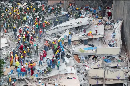  ?? REBECCA BLACKWELL/AP PHOTO ?? Rescue workers search for people trapped inside a collapsed building in the Del Valle area of Mexico City on Wednesday. Mexicans across the city are digging through collapsed buildings, trying to save people trapped in debris under schools, homes and...