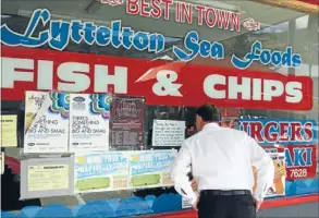  ??  ?? Checking it out: Prime Minister John Key looks into a fish and chip shop at Lyttelton. The shop closed because of earthquake damage.