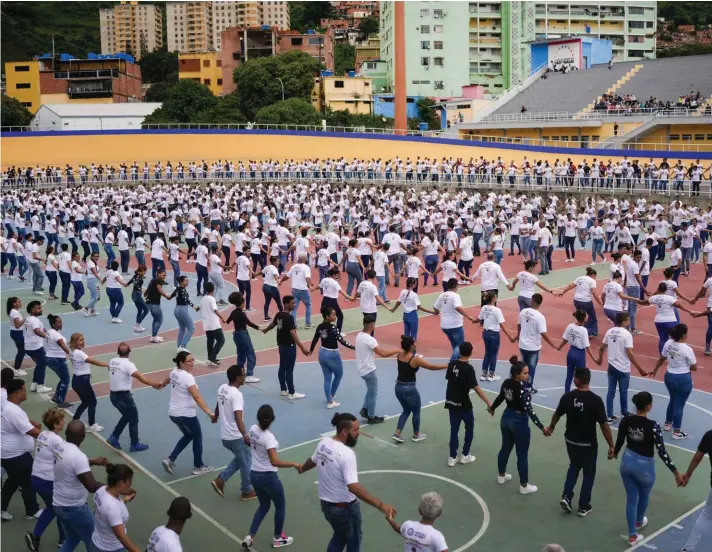  ?? ?? Dance fans attend a Guinness World Record attempt, which was held at the Teo Capriles velodrome of the National Sports Institute in Caracas, Venezuela, on Sunday. The group is part of Venezuela's Salsa Casino dance schools, which intend to break the Guinness World Record for the largest number of couples dancing this type of Latin rhythm. Photo: AP/Matias Delacroix