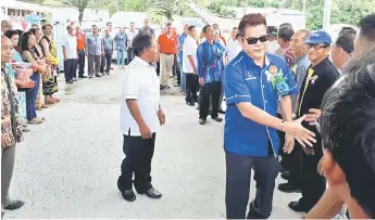  ??  ?? APA KHABAR?: Dr Rayong (depan) dan Nyalau (belakang, sedkit terlindung) berjabat tangan dengan hadirin yang menyambut kedatangan mereka pada majlis tersebut.