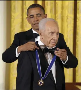  ?? SUSAN WALSH — ASSOCIATED PRESS ?? President Barack Obama awards Israeli President Shimon Peres with the Presidenti­al Medal of Freedom at a dinner at the East Room of the White House in Washington, D.C., in 2012.