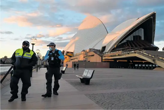  ?? Photo / Getty Images ?? Police officers walk past the Opera House during lockdown in Sydney.