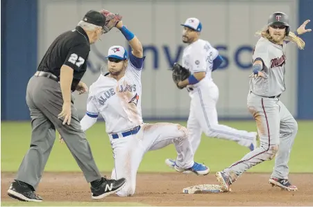  ??  ?? Twins base runner Taylor Motter comes up safe stealing second base as Blue Jays shortstop Lourdes Gurriel Jr. tries to make the tag during the fifth inning in Toronto on Tuesday.