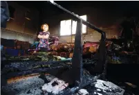  ?? (Abed Omar Qusini/Reuters) ?? A GIRL STANDS inside the torched house of the Dawabsheh family last month in the village of Duma near Nablus.