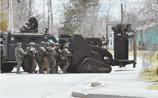  ??  ?? HOAX DRAWS HEAVY ARMOR: The Metropolit­an Law Enforcemen­t Council SWAT team moves in on a house on Pearl Street in Stoughton after a report of a home invasion — which later was determined to be a false ‘swatting’ call.